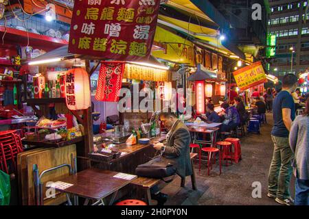 TAIPEH, TAIWAN - 4. DEZEMBER 2018: Menschen besuchen Raohe Nachtmarkt in Taipeh. Nachtmärkte sind ein großer Teil der taiwanesischen Kultur. Stockfoto