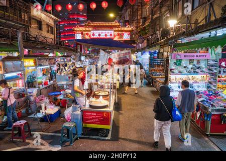 TAIPEH, TAIWAN - 4. DEZEMBER 2018: Menschen besuchen Raohe Nachtmarkt in Taipeh. Nachtmärkte sind ein großer Teil der taiwanesischen Kultur. Stockfoto