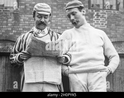 Ein altes, spätes viktorianisches Schwarz-Weiß-Foto in englischer Sprache, auf dem zwei Männer in historischer Sportkleidung, vielleicht für Cricket oder Rudern, beim Lesen einer Ausgabe der Zeitung Sporting Times, bekannt als Pink 'UN, zu sehen sind. Ein Mann rauchte eine Pfeife. Stockfoto