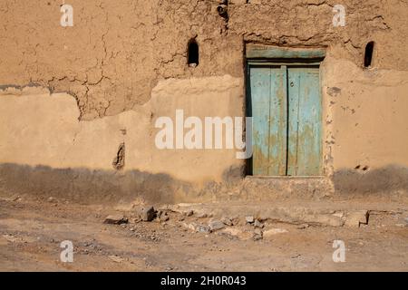 Die schönen alten verlassenen Ruinen Schlamm oder Lehmwand und Holztür des alten Hauses Stockfoto