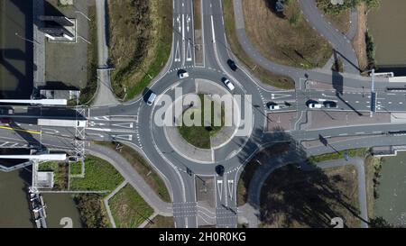 Luftaufnahme eines kleinen Kreisel an der Kreuzung zweier asphaltierter grauer Landstraßen in den Niederlanden Stockfoto