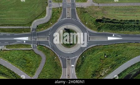 Luftaufnahme eines kleinen Kreisel an der Kreuzung zweier asphaltierter grauer Landstraßen in den Niederlanden Stockfoto