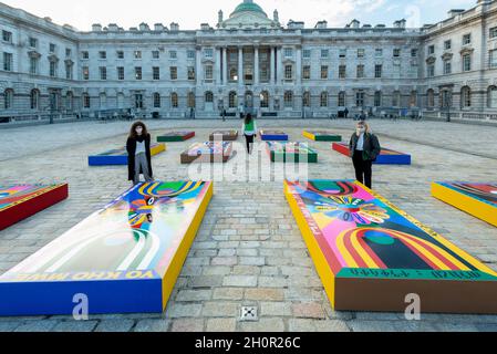 London, Großbritannien. 14. Oktober 2021. Die Mitarbeiter sehen die Bilder von Lakwena Macivers Basketballplatz im Innenhof des Somerset House. Vorschau auf die 1-54 Contemporary African Art Fair, die führende internationale Kunstmesse für zeitgenössische Kunst aus Afrika und seiner Diaspora. Werke von rund 48 Ausstellern sind in einer Ausstellung zu sehen, die vom 14. Bis 17. Oktober im Somerset House stattfindet. Kredit: Stephen Chung / Alamy Live Nachrichten Stockfoto