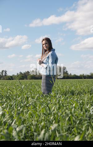 Vertikale Aufnahme einer jungen kaukasischen Dame aus Argentinien, die in einem sonnigen Landfie posiert Stockfoto