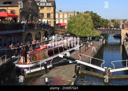 Ein Narrowboot, das durch die Hampstead Road fährt, führt über den Regent's Canal. Die Schlösser sind vom Camden Lock Markt. Regent's Canal, Camden, London, Stockfoto