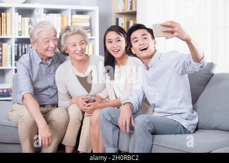 Die glückliche Familie nimmt ein Selfie mit ihrem Telefon Stockfoto