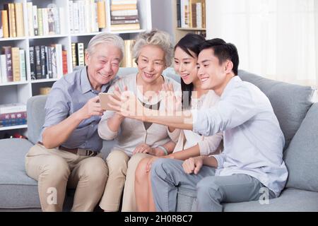 Die glückliche Familie nimmt ein Selfie mit ihrem Telefon Stockfoto