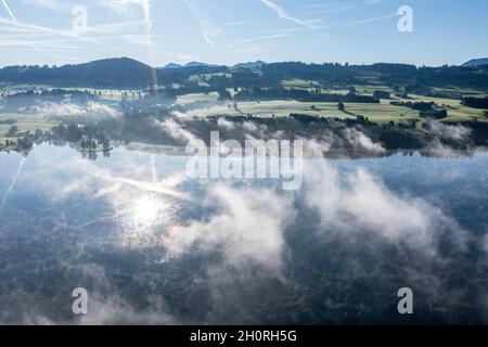 Luftaufnahme über den Rottachsee zum Dorf Petersthal, Herbstnebel, Allgau, Bayern, Deutschland. Stockfoto