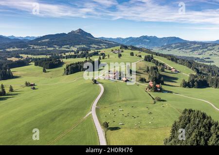 Luftaufnahme der Landstraße in Wiesen, Bauernhof Binzeler, Berg Gruenten im Hintergrund, Allgau, Deutschland. Stockfoto