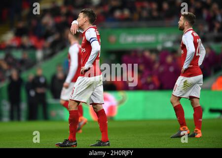 Arsenal-Spieler scheinen niedergeschlagen zu sein, als David Silva von Manchester City das dritte Tor seiner Mannschaft feiert Stockfoto