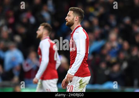 Arsenal-Spieler scheinen niedergeschlagen zu sein, als David Silva von Manchester City das dritte Tor seiner Mannschaft feiert Stockfoto