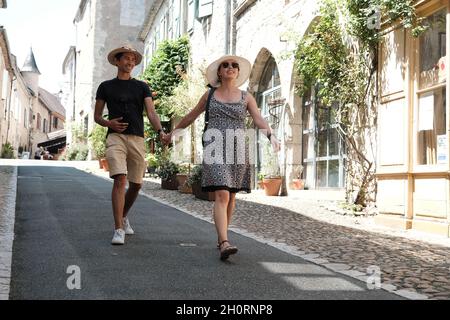 Lächelndes Paar, das die Hände auf der Straße hält, Carennac, Quercy, Lot, Oczitanie, Frankreich Stockfoto