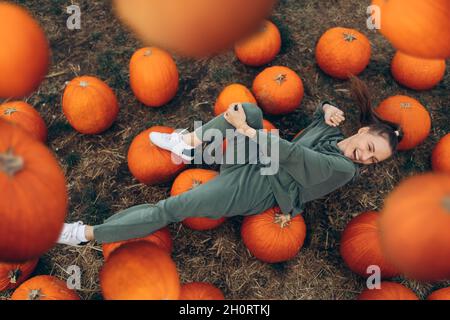 Schöne Frau liegt auf einem Feld auf Kürbissen. Stockfoto
