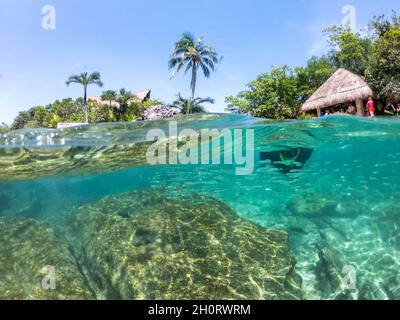 Cancun, Mexiko - 13. September 2021: Split Unterwasseransicht in Schnorchellagune im Xcaret Park am Mayan Riviera Resort. Xcaret ist ein berühmter Stockfoto