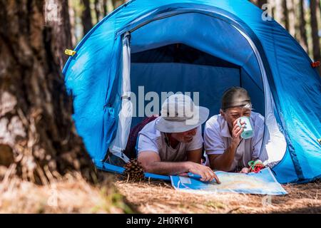 Pensionspaar Lifestyle Genießen Sie Reisen Tourismus Urlaub in einem Zelt in freien wilden Camping im Freien liegen - ältere Menschen und das Gefühl mit Natur Holz Stockfoto