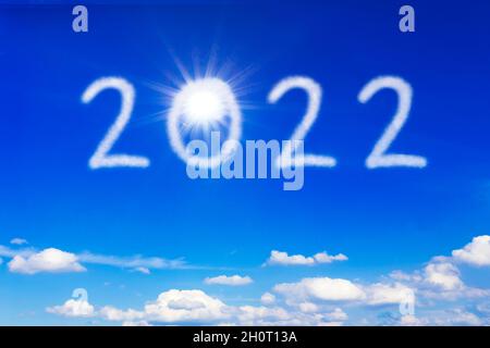 Happy New Year Konzept. Die Sonne und die Zahl 2022 am blauen Himmel, Symbol für eine strahlende Zukunft, Freiheit und Normalität. Stockfoto