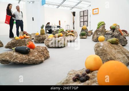 London, Großbritannien, 14. Oktober 2021: Die Frieze Art Fair eröffnet in London mit zeitgenössischer Kunst aus aller Welt. Die Installation des Künstlers Edgar Calel 'Ru k' OX k'ob'el jun ojer etemab'el (das Echo einer antiken Form des Wissens)' legt Früchte auf Felsen als Opfergaben an die Erde. Die Schau legt sowohl in den gezeigten Arbeiten als auch im Vergleich zu den Vorjahren einen Schwerpunkt auf die Vermeidung von Klimakatastrophen. Anna Watson/Alamy Live News Stockfoto