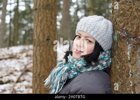 Junge Frau in Winterkleidung im Wald Stockfoto