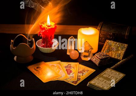 Stillleben mit Tarot-Karten, Kerzen, Weihrauch und anderen Gegenständen auf einem schwarzen Kartentisch während einer Weissagung. Konzept einer Weissagung wi Stockfoto