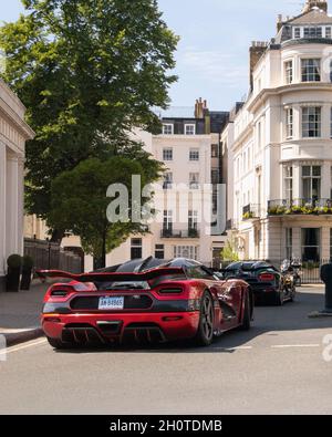 Die Supercars Red Koenigsegg Agera XS und Green Agera R fahren auf einer Straße im Stadtteil Belgravia im Zentrum von London, England. Stockfoto