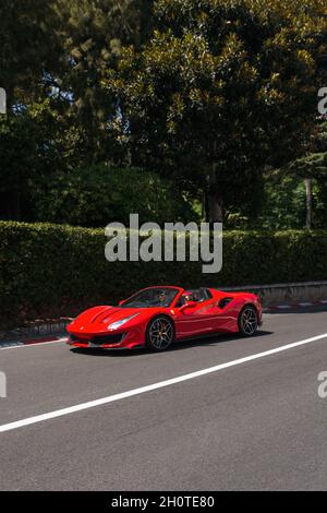 Red Ferrari 488 Pista Spider Supersportwagen, der auf einer Straße im Zentrum von Monaco gefahren wird, die Teil der F1-Strecke ist. Stockfoto