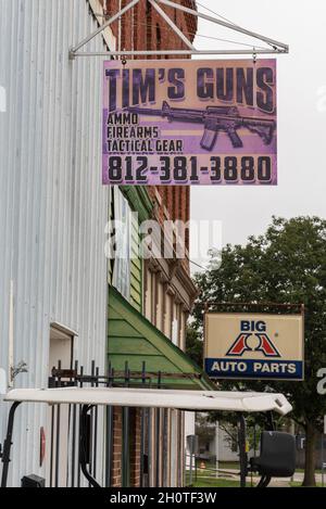 Auf einem violetten Schild auf dem Aluminiumgebäude steht: Tim’s Guns, Ammo, Firearms, Tactical Gear. Im Hintergrund ist ein Schild für Big A Auto Parts, Worthington, in. Stockfoto