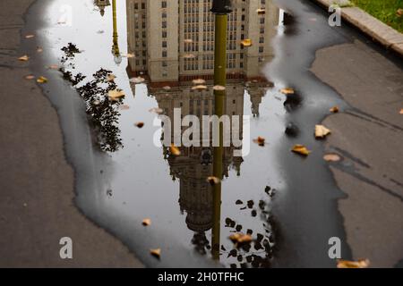 Moskau, Russland september 11. 2021 Spiegelung des Hauptgebäudes der Staatlichen Universität Moskau in einer Pfütze, Herbstarchitektur nach Regen Stockfoto