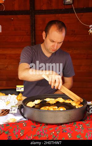 POZNAN, POLEN - 15. Aug 2013: Ein Mann, der Käse während eines Food Festivals auf dem alten Stadtplatz in Poznan, Polen, serviert Stockfoto