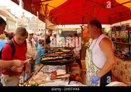 POZNAN, POLEN - 15. Aug 2013: Ein Mann, der während eines Festivals auf dem alten Stadtplatz in Poznan, Polen, Essen verkauft Stockfoto