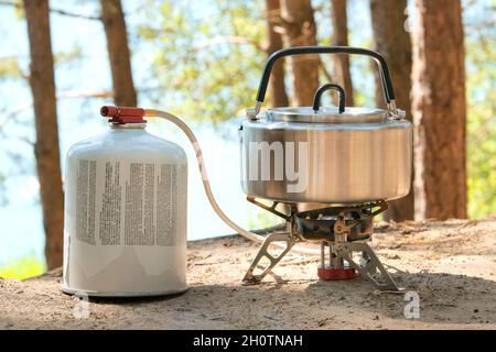 Essen für Reisende für Outdoor-Aktivitäten. Tee im Topf im grünen Wald. Camping Lebensmittelherstellung. Stockfoto