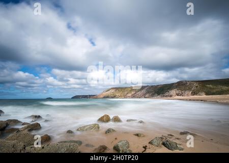 Verschwommener Blick auf glatte Wellen zwischen Felsen im Ozean Stockfoto