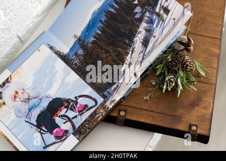 Luxus Holz Fotobuch, Holzkiste mit Sommerfotos gedruckt und Flash-Karte auf Leinen natürlichen Hintergrund. Fotobuch für Familienerinnerungen. Speichern Sie Ihr Stockfoto