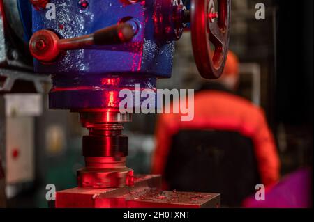 Eine altmodische vertikale Fräsmaschine schneidet ein Metallteil Stockfoto