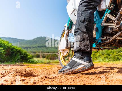 Nahaufnahme eines Bikerschuhs auf dem Schlamm vom Boden aus gesehen Stockfoto