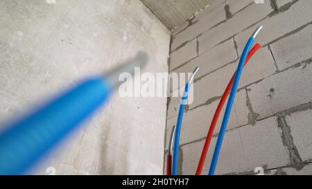 Heißes und kaltes Wasser im Badezimmer. Installation von heißen und kalten Rohren. Stockfoto
