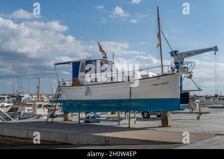 S'Estanyol, Spanien; oktober 09 2021: Freizeitboot auf Metallstativen für die zukünftige Restaurierung unterstützt. S'Estanyol Marina, Insel Mallorca, Spanien Stockfoto