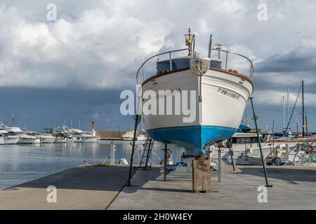 S'Estanyol, Spanien; oktober 09 2021: Freizeitboot auf Metallstativen für die zukünftige Restaurierung unterstützt. S'Estanyol Marina, Insel Mallorca, Spanien Stockfoto