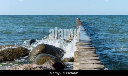 Wellen und ein Sturm auf See. Wellen krachen über Wellenbrecher. Meereswellen plätschern. Ostsee. Stockfoto