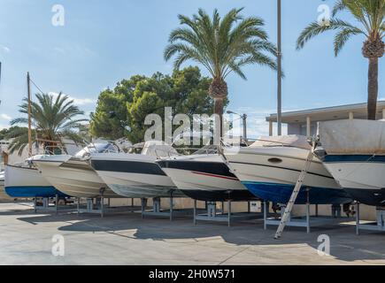 Freizeitboote auf Metallstativen für die zukünftige Restaurierung unterstützt. S'Estanyol Marina, Insel Mallorca, Spanien Stockfoto