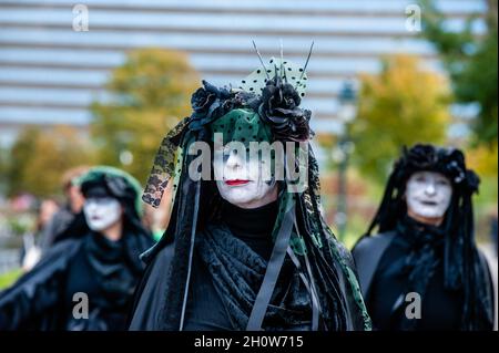 Den Haag, Niederlande. Oktober 2021. Drei schwarze Rebellen werden gesehen, wie sie während der Aufführung für die Kameras posieren. Im Rahmen der neuen Kampagne „Extinction Rebellion“ „Climate Rebellion“ gingen Hunderte von Klimaaktivisten in schwarzer Kleidung in einer Trauerprozession durch das Zentrum von Den Haag, um das Gedenken an die Opfer des Klimawandels und der ökologischen Krise zu ehren. Die stille Prozession wurde von den Schwarzen Rebellen geführt und von mehreren Parteibüros in der Stadt passiert. Kredit: SOPA Images Limited/Alamy Live Nachrichten Stockfoto