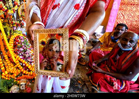 Kalkutta, Indien. Oktober 2021. Ein Bild eines kleinen Mädchens Dipwantita Adhikary von 10 Jahren wird von den Hindu-Anhängern während des Kumari-Puja-Rituals gezeigt. Kumari Puja ist eine indische Hindu-Tradition, die hauptsächlich während der Durga Puja nach dem Hindu-Kalender gefeiert wird. Kumari beschreibt tatsächlich ein junges jungfräuliches Mädchen im Alter von 1 bis 16 Jahren, das nach der hinduistischen Mythologie während des Übergangs von Ashtami/Navami Tithiti von Durga Puja/Navratri verehrt wird. Kredit: SOPA Images Limited/Alamy Live Nachrichten Stockfoto