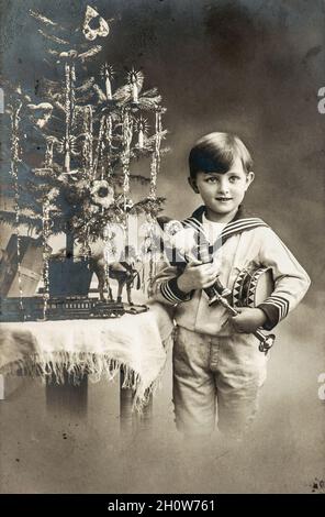 Weihnachtsbaum und Vintage-Spielzeug. Glückliches Kind mit Geschenken. Vintage-Bild Stockfoto
