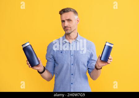 Guy wählen Shampoo-Flasche oder Haarspülung. Tägliche Gewohnheiten und persönliche Pflege. Stockfoto