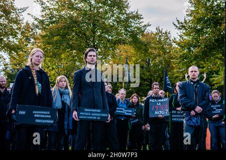 XR-Aktivisten werden gesehen, wie sie vor Beginn der Prozession einer kurzen Rede lauschen, während sie Plakate halten und schwarze Kleidung tragen. Im Rahmen der neuen Kampagne „Extinction Rebellion“ „Climate Rebellion“ gingen Hunderte von Klimaaktivisten in schwarzer Kleidung in einer Trauerprozession durch das Zentrum von Den Haag, um das Gedenken an die Opfer des Klimawandels und der ökologischen Krise zu ehren. Die stille Prozession wurde von den Schwarzen Rebellen geführt und von mehreren Parteibüros in der Stadt passiert. (Foto von Ana Fernandez/SOPA Images/Sipa USA) Stockfoto