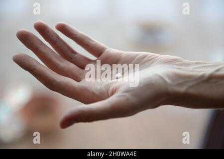 Bild einer Frau mit Pillen in der Hand Stockfoto
