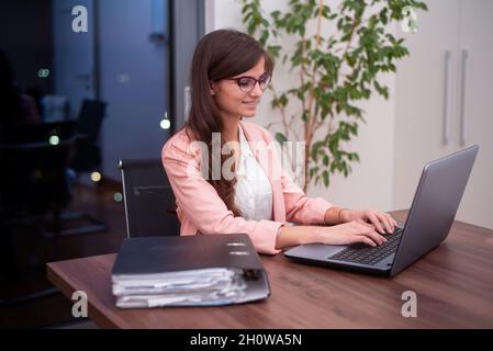 Junge Geschäftsfrau Arbeiten auf Ihrem Laptop Stockfoto