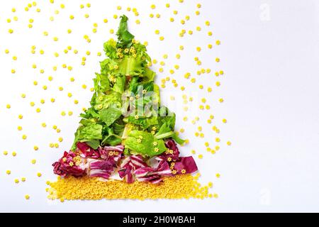 Weihnachtsbaum aus grünen Salatprodukten, Kohl und roher Pasta. Für Text platzieren Stockfoto