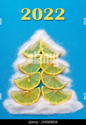 Weihnachtsbaum aus Zitronen- und Zuckerfrüchten auf blauem Hintergrund. Stockfoto
