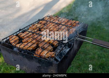 Leckere Hähnchenbeine und Flügel auf dem Grill. Stockfoto