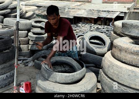 Dhaka, Bangladesch. Oktober 2021. Arbeiter aus Bangladesch schnitten am 14. Oktober 2021 in Dhaka alte Reifen, die recycelt werden sollen. ( Credit: SIPA USA/Alamy Live News Stockfoto